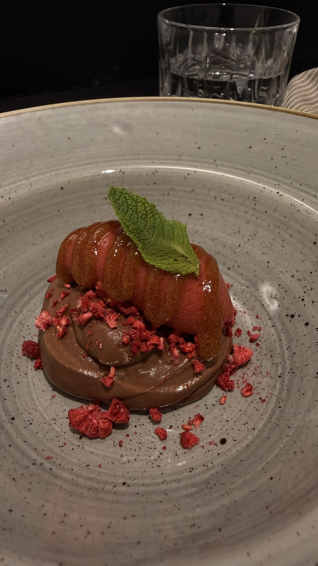 Himbeer-Rote-Beete-Sorbet mit Schokoladencréme Himbeer-Rote-Beete-Sorbet mit Schokoladencréme, Malz-Bier-Gel, Himbeerpulver und Schmetterlingshippe, kunstvoll angerichtet auf einem Teller.