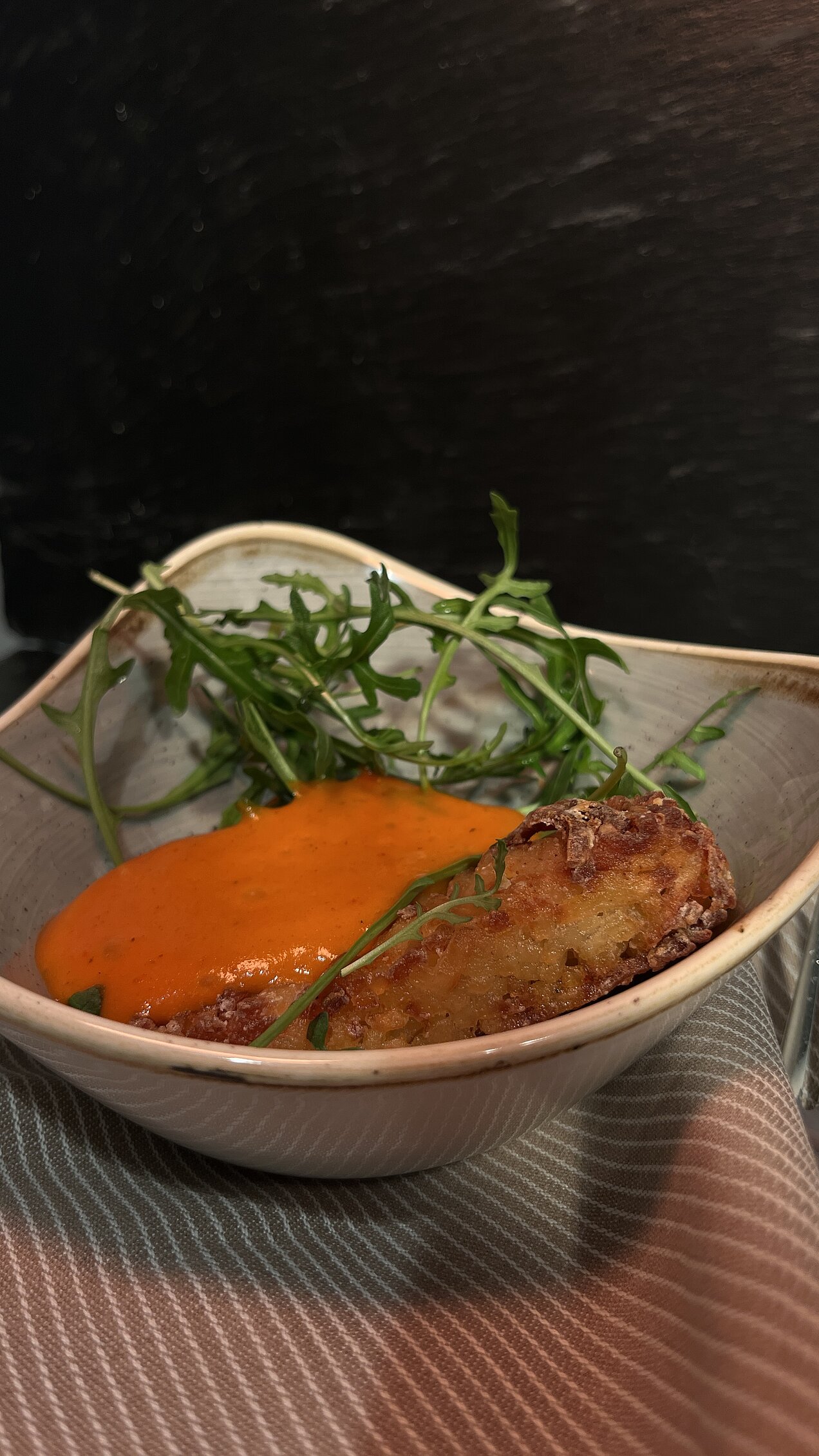 Wildschwein-Currywurst mit Tomaten-Curry-Espuma Sous-vide gegarte Wildschwein-Currywurst mit Tomaten-Curry-Espuma, eingelegter roter Zwiebel und Pommes Pailles, serviert beim Genussabend Craft & Comfort.