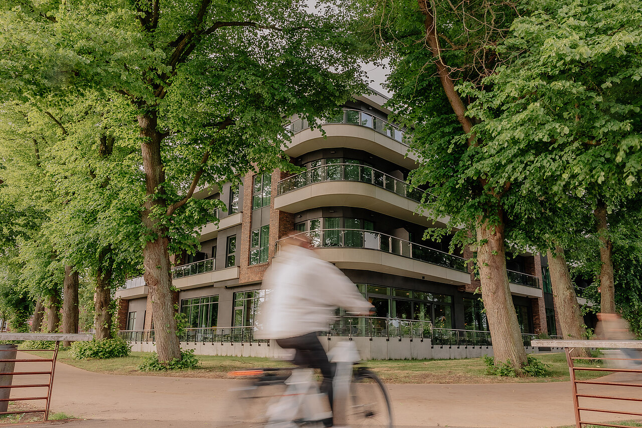 Radfahrerin am VIA PLAZA Hotel Meppen Radfahrerin vor dem grün umrahmten VIA PLAZA Hotel in Meppen