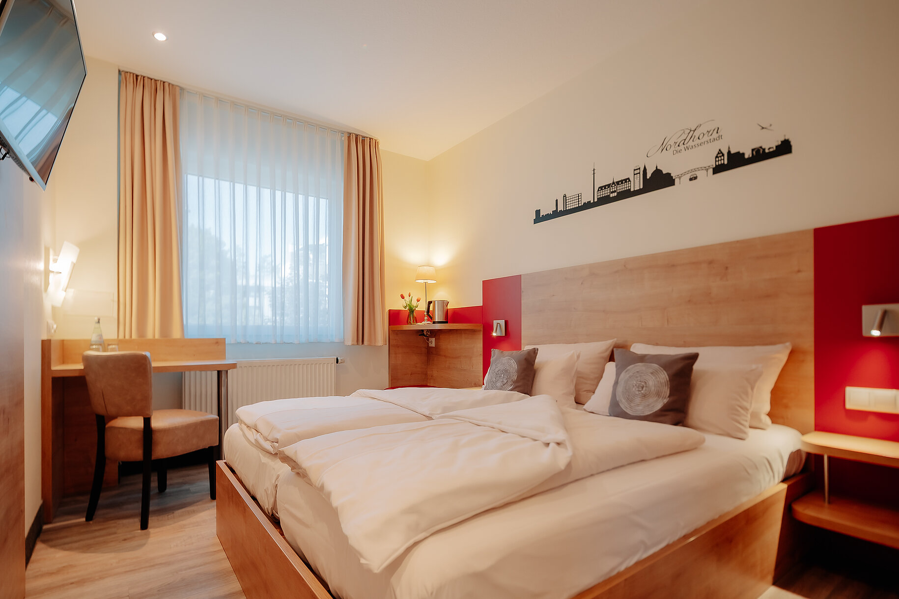 Doppelzimmer Standard im INSIDE Hotel Nordhorn Doppelzimmer Standard im INSIDE Hotel Nordhorn mit Wandgrafik der Stadt