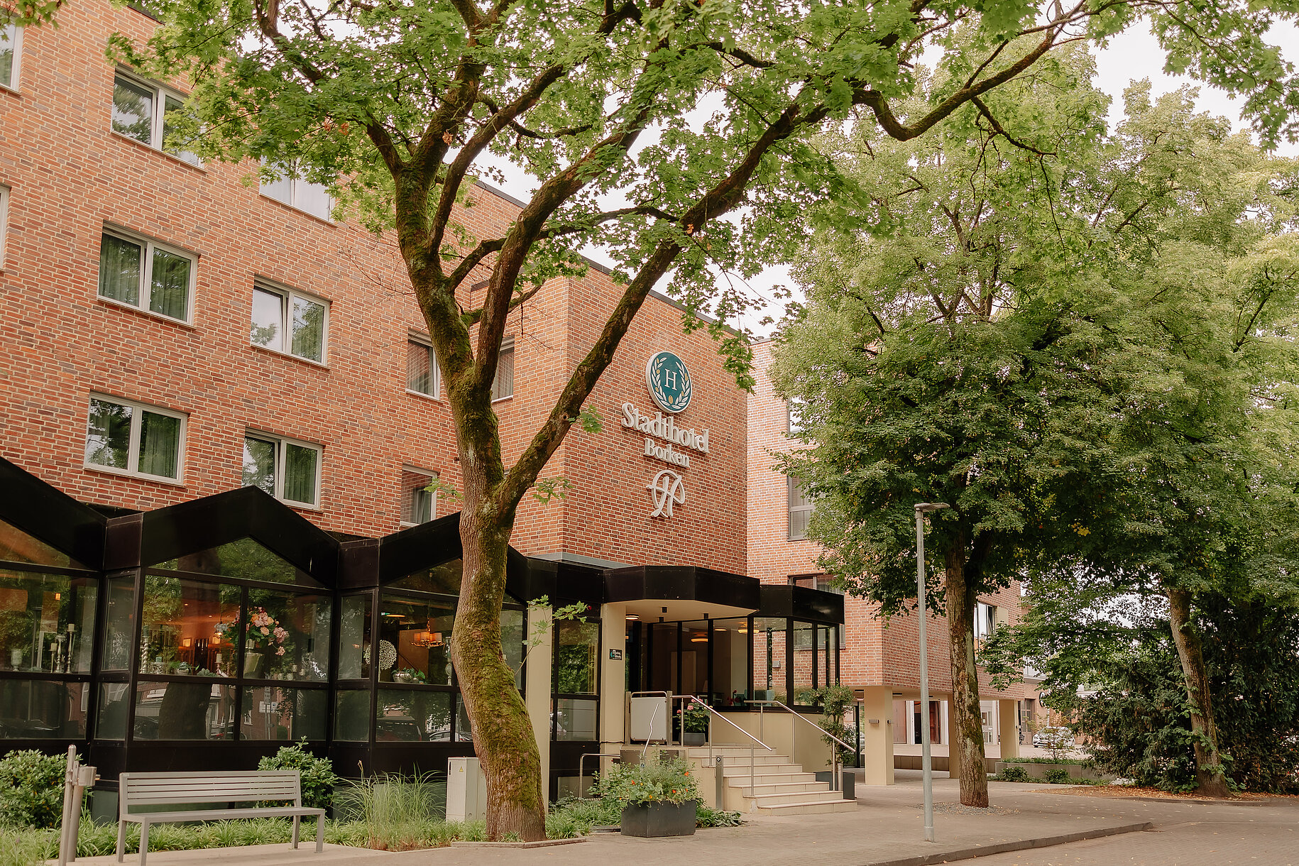 Stadthotel Borken by Hackmann – Außenansicht Außenansicht des Stadthotel Borken by Hackmann mit Eingangsbereich und Bäumen