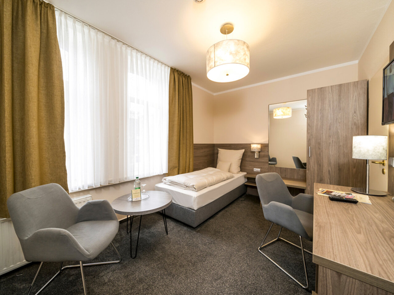 Einzelzimmer im Parkhotel Lingen Einzelzimmer mit Schreibtisch und Sessel im Parkhotel Lingen