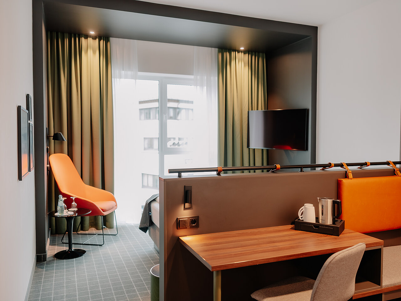 Arbeitsbereich im Doppelzimmer Superior mit Stadtblick Doppelzimmer Superior im VIA PLAZA Meppen mit Schreibtisch, Lounge-Sessel und Stadtblick