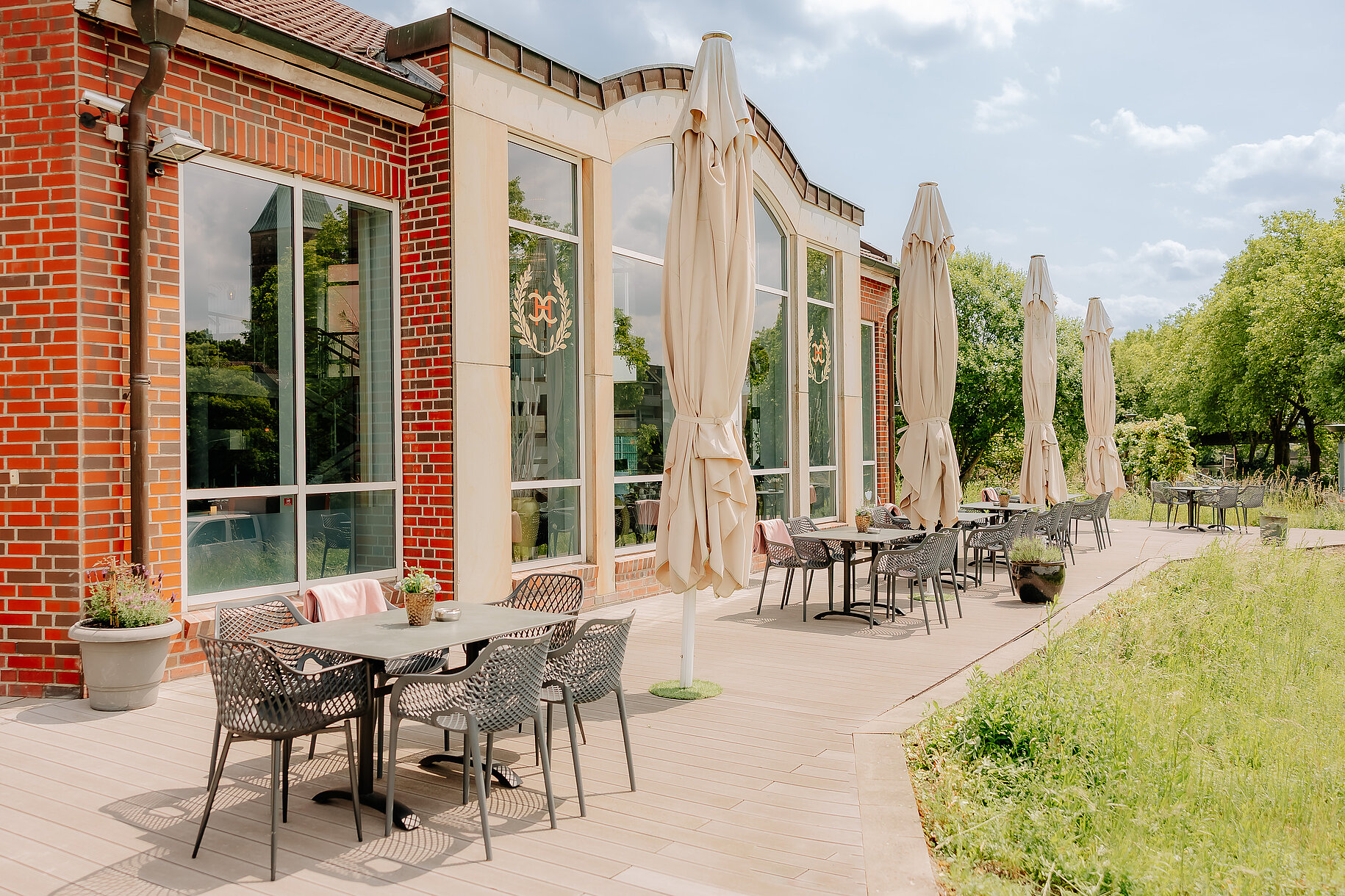 Terrasse am CASCADA Hotel Rheine Sonnenterrasse mit Tischen, Stühlen und Sonnenschirmen am CASCADA Hotel Rheine