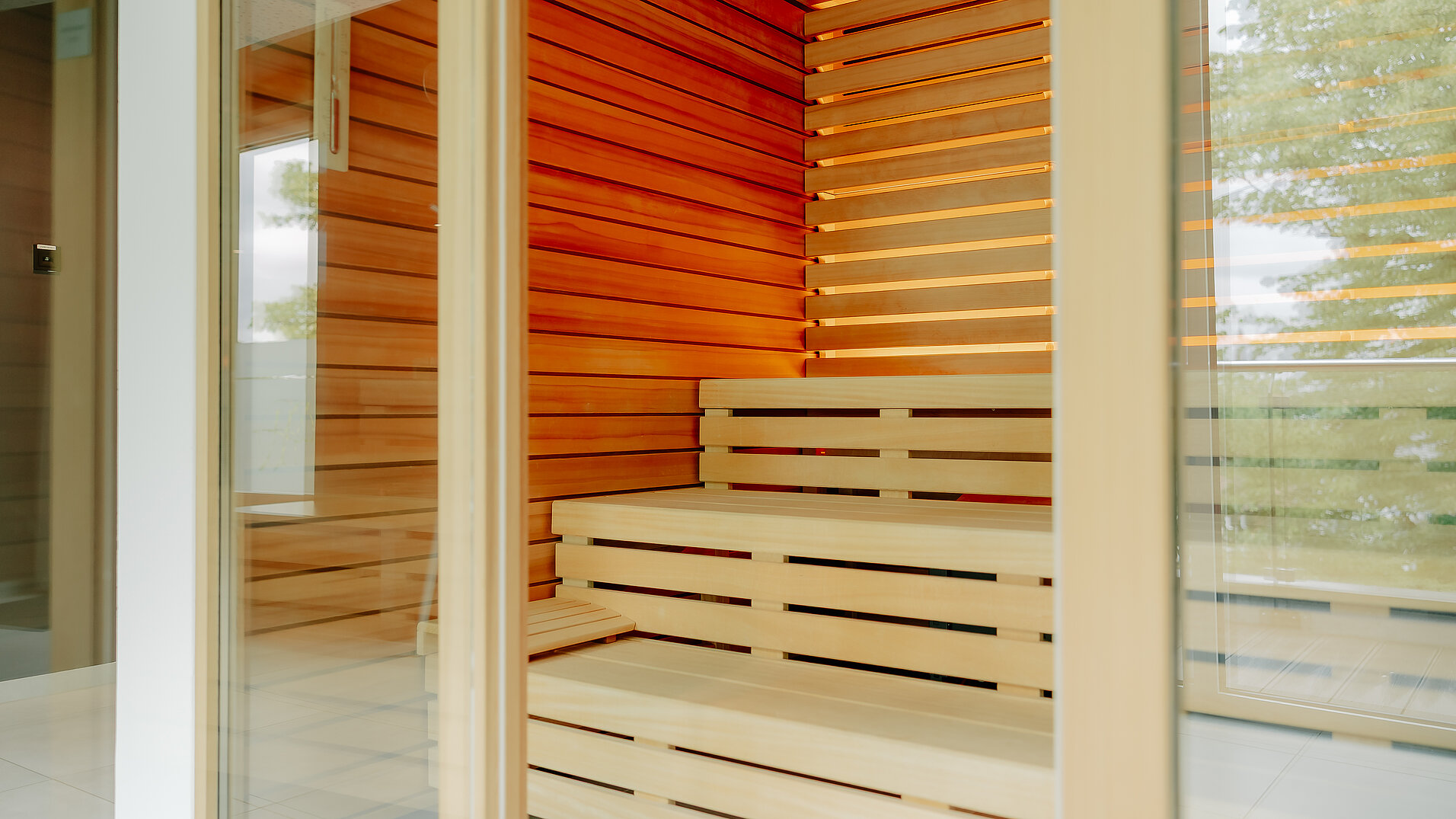 Moderne Sauna mit Glasfront im VIA PLAZA Meppen Blick durch die Tür in eine Sauna mit klarer Holzstruktur