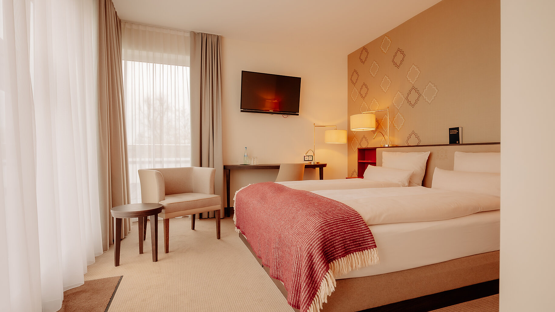Doppelzimmer Deluxe im LOOKEN INN Lingen Helles Hotelzimmer mit Doppelbett, Schreibtisch und gemütlicher Sitzecke im LOOKEN INN Lingen
