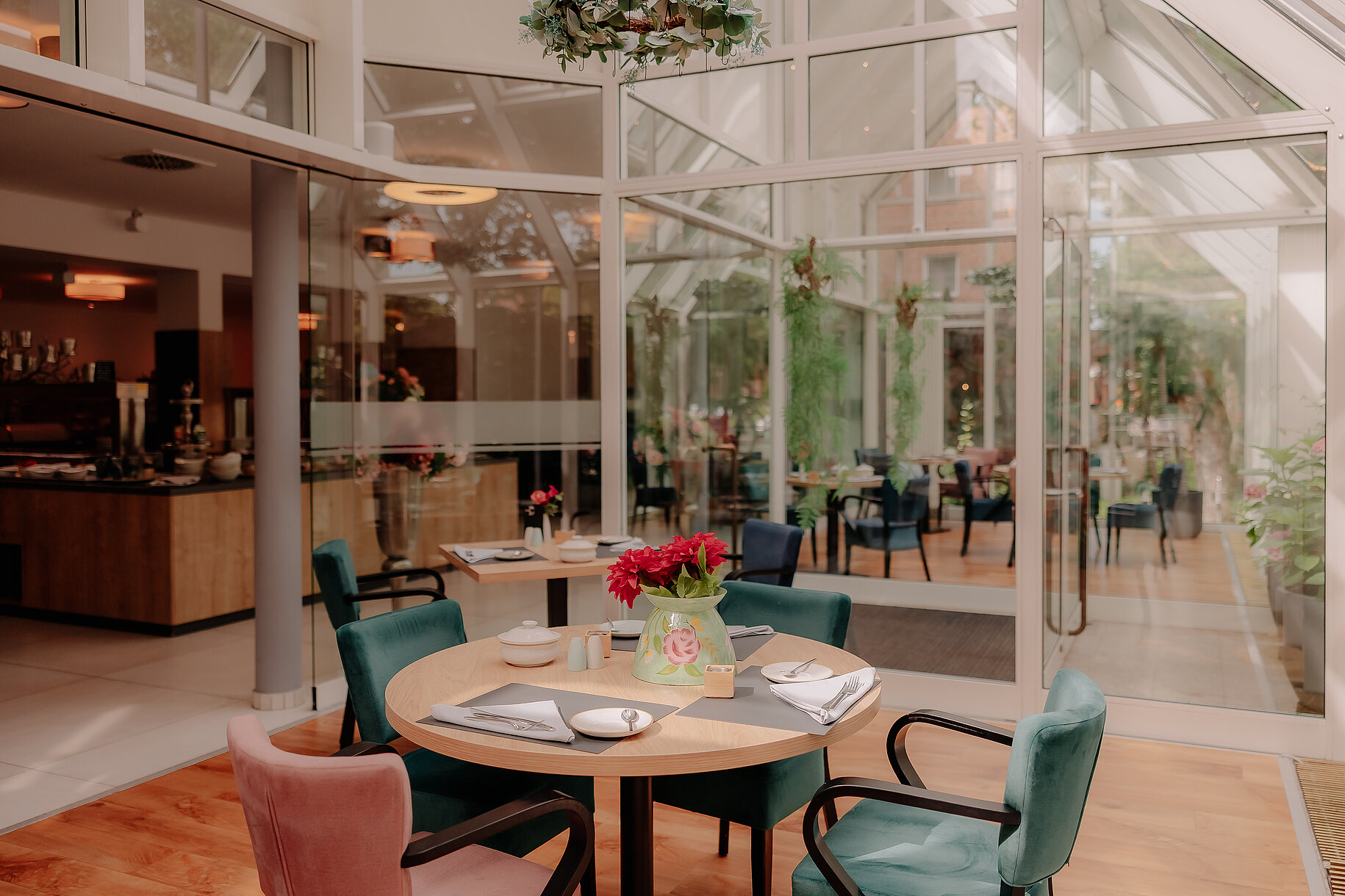 Wintergarten mit gedecktem Tisch im Stadthotel Borken Frühstückstisch im Wintergarten des Stadthotels Borken mit bunter Dekoration und Blick auf den lichtdurchfluteten Gastraum