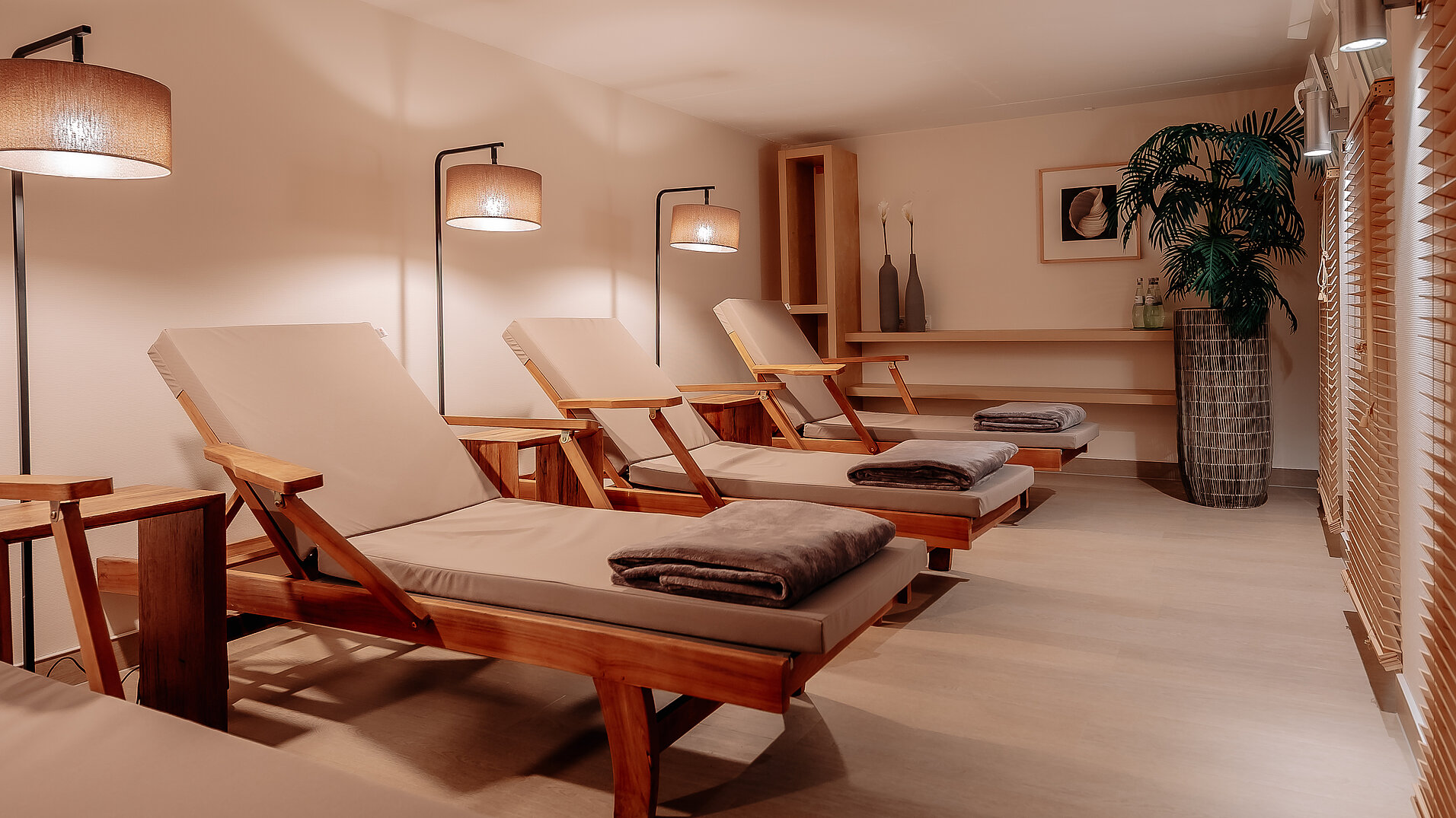 Ruhebereich mit Liegen und Lampen im INSIDE Hotel Nordhorn Wellnessraum mit mehreren Liegen und Stehlampen im INSIDE Hotel Nordhorn