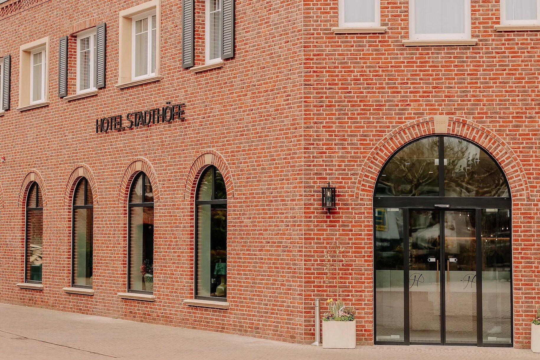 Hotel Stadthöfe Rhede – Außenansicht Außenansicht des Hotel Stadthöfe Rhede mit roter Klinkerfassade und Rundbogenfenstern
