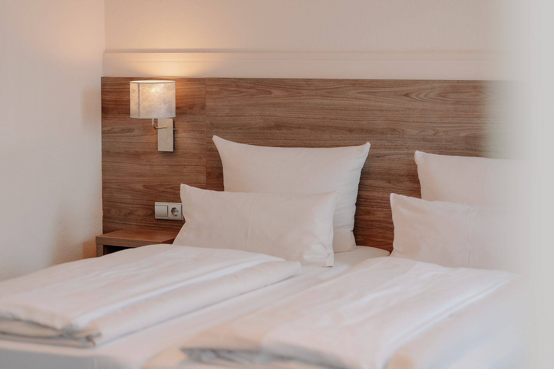 Betten im Parkhotel Lingen Zwei bezogene Betten mit Holzkopfteil im Parkhotel Lingen