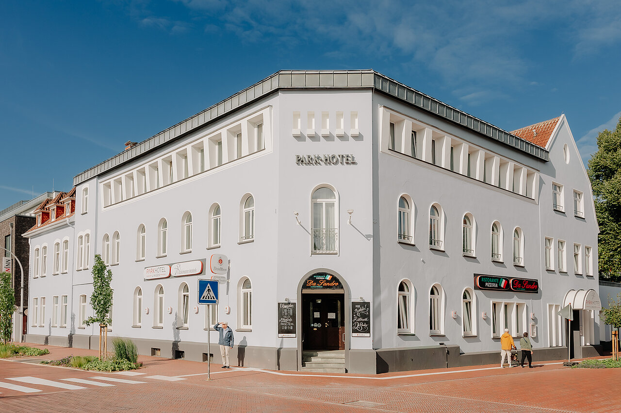 Historische Außenansicht Parkhotel Lingen Außenansicht des Parkhotel Lingen by Hackmann mit heller historischer Fassade an einer Straßenkreuzung.
