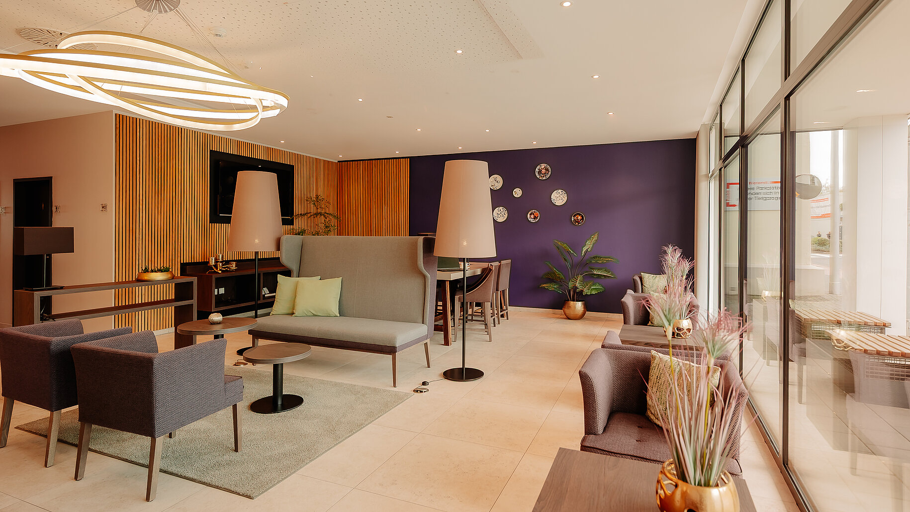 Loungebereich mit Akzentwand im LOOKEN INN Lingen Stilvoll eingerichteter Loungebereich mit violetter Akzentwand und modernen Sitzmöbeln im LOOKEN INN Lingen