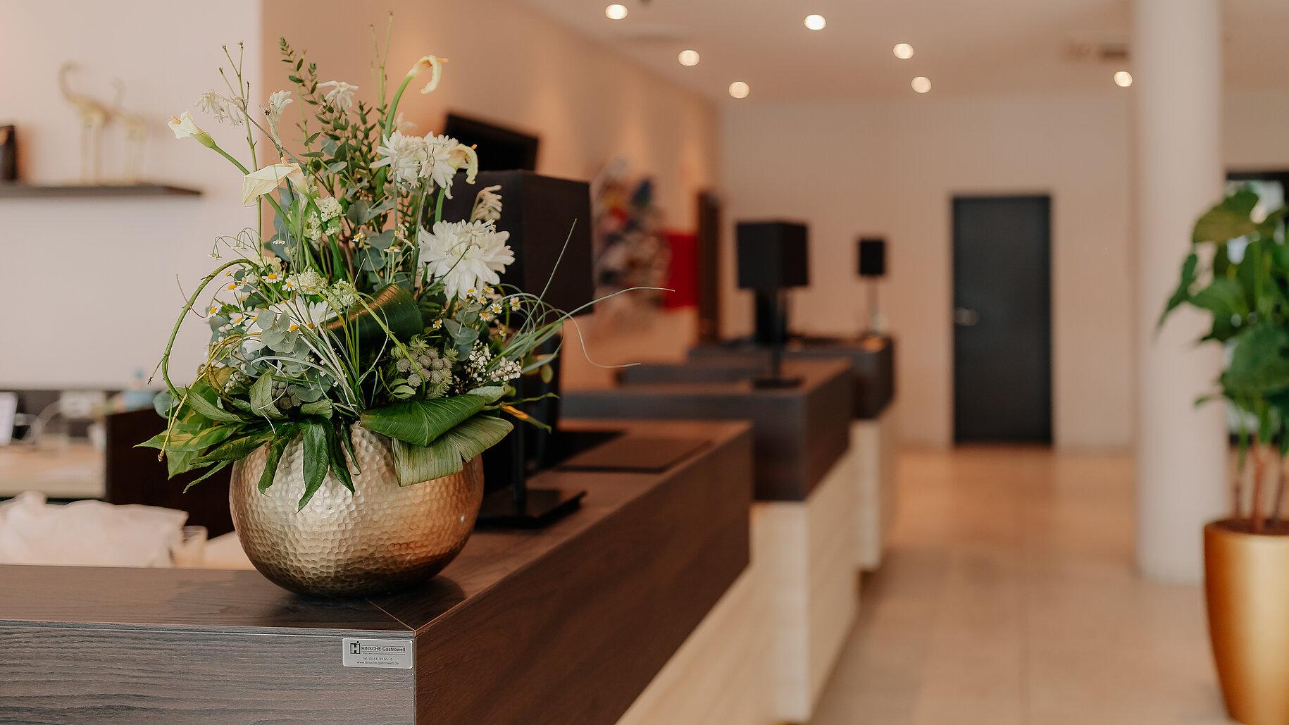 Rezeption im LOOKEN INN Lingen Empfangsbereich im LOOKEN INN Lingen mit stilvollem Blumenschmuck auf der Theke