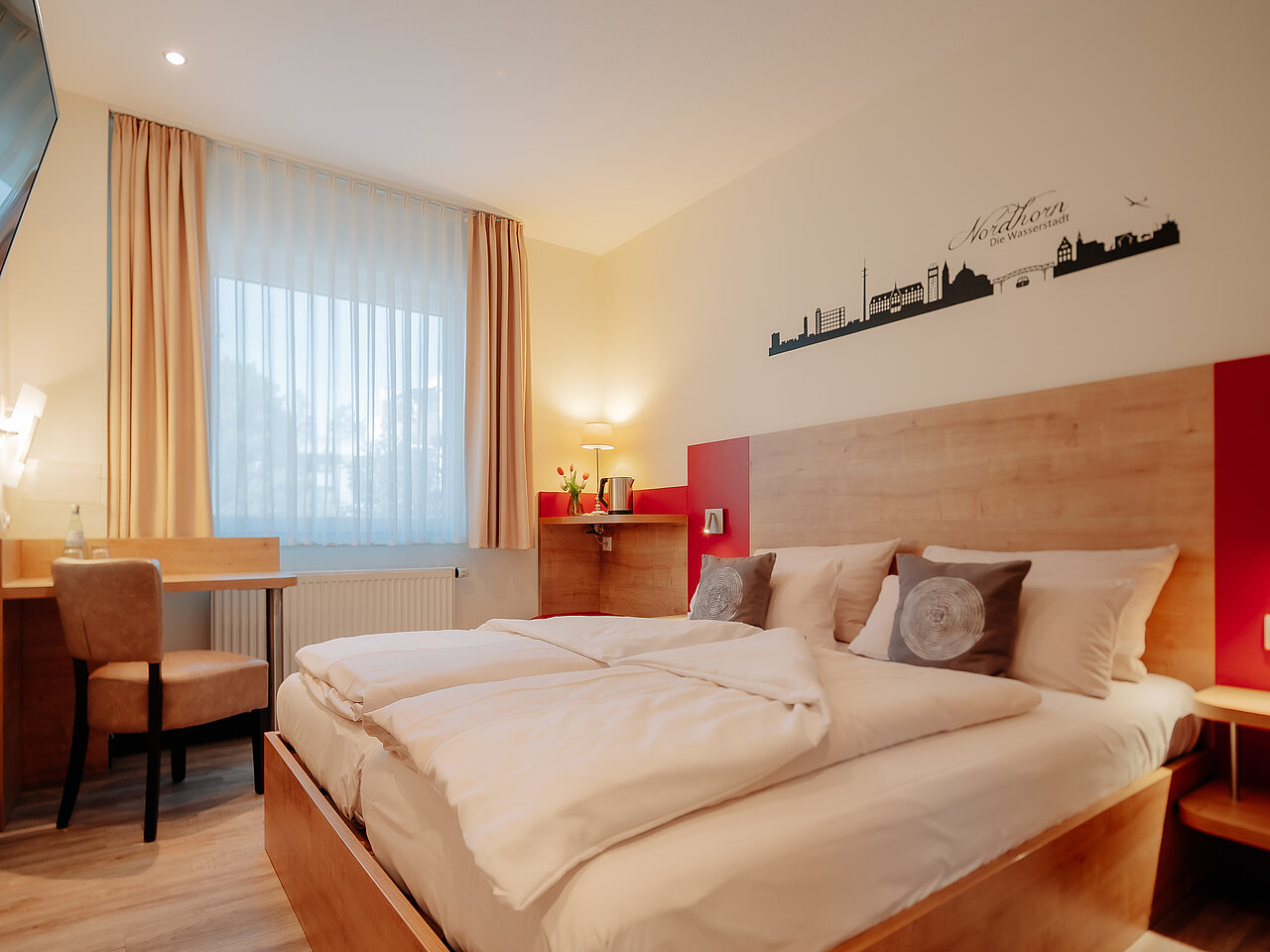 Doppelzimmer Standard im INSIDE Hotel Nordhorn Doppelzimmer Standard im INSIDE Hotel Nordhorn mit Wandgrafik der Stadt