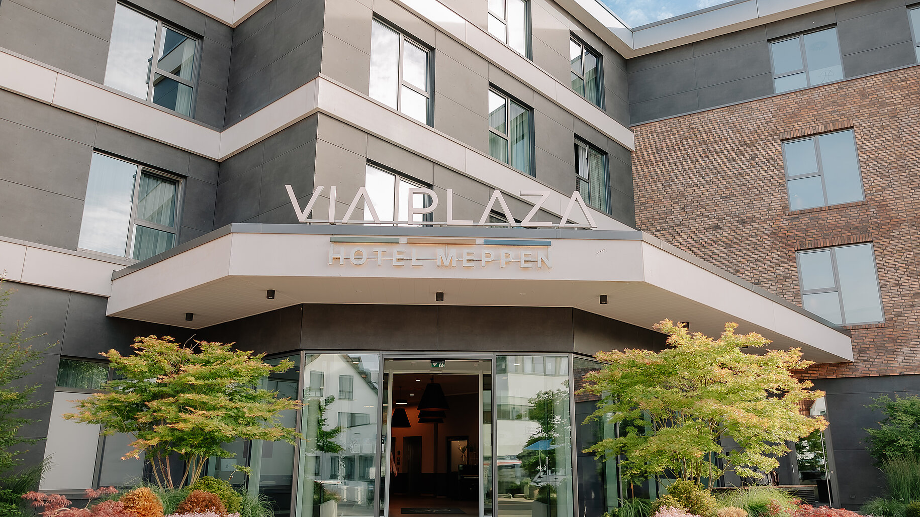 Hauptzugang zum VIA PLAZA Meppen Hotel Haupteingang des VIA PLAZA Meppen mit Glasfront und begrüntem Eingangsbereich