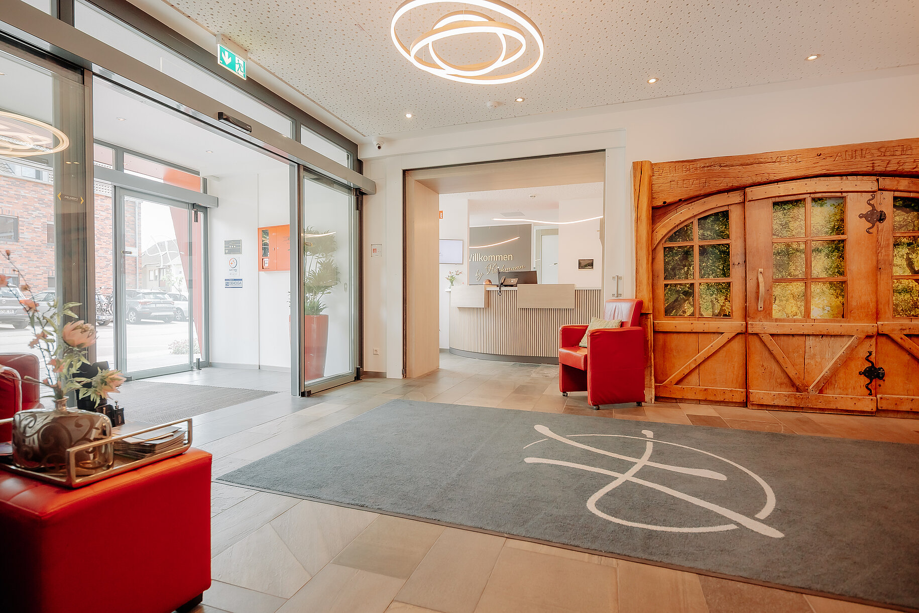 Empfangsbereich Parkhotel Papenburg Moderner Eingangsbereich mit Blick auf die Rezeption und rustikale Holztür im Parkhotel Papenburg