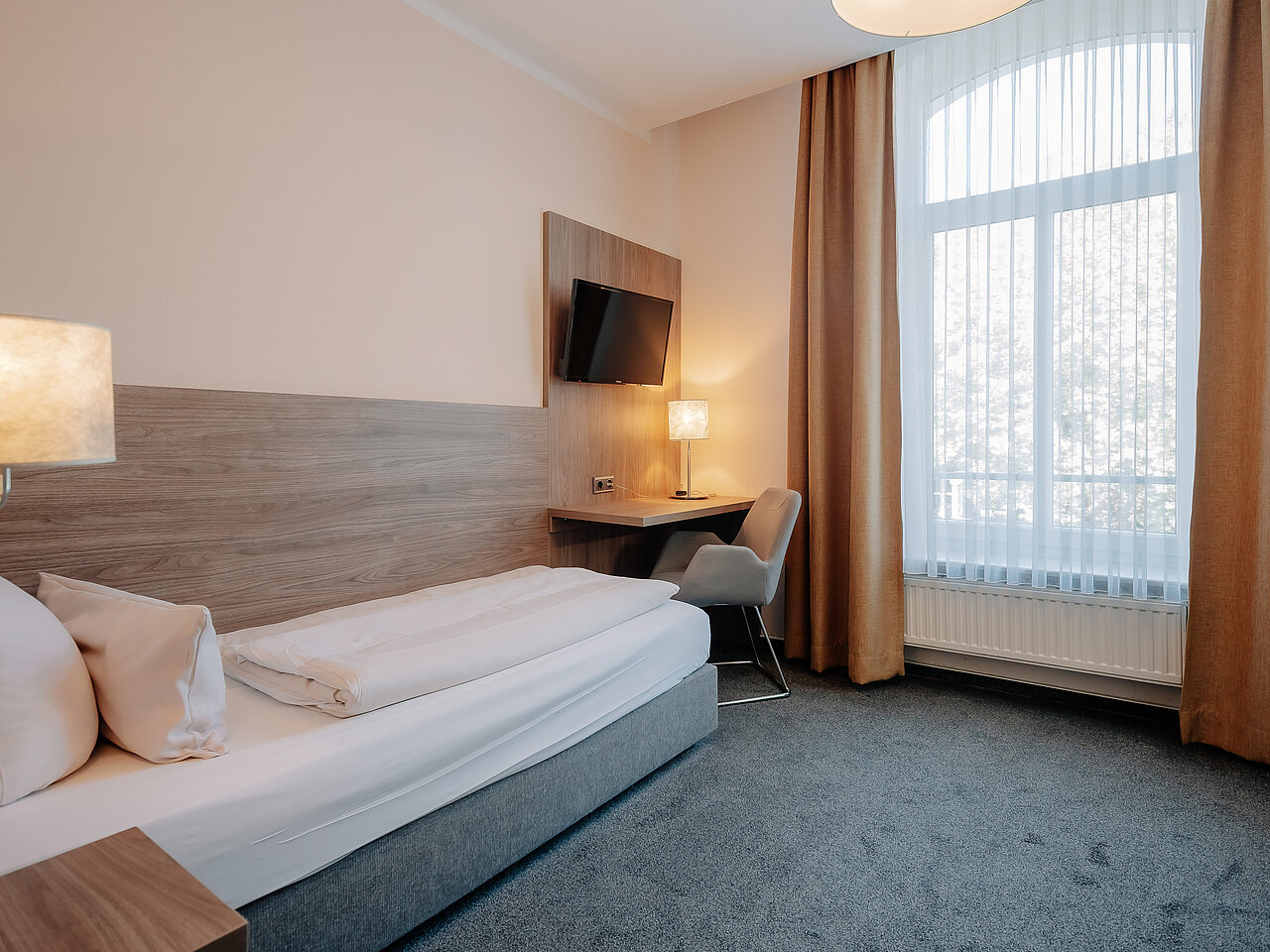 Einzelzimmer im Parkhotel Lingen Einzelzimmer mit Schreibtisch und Sessel im Parkhotel Lingen