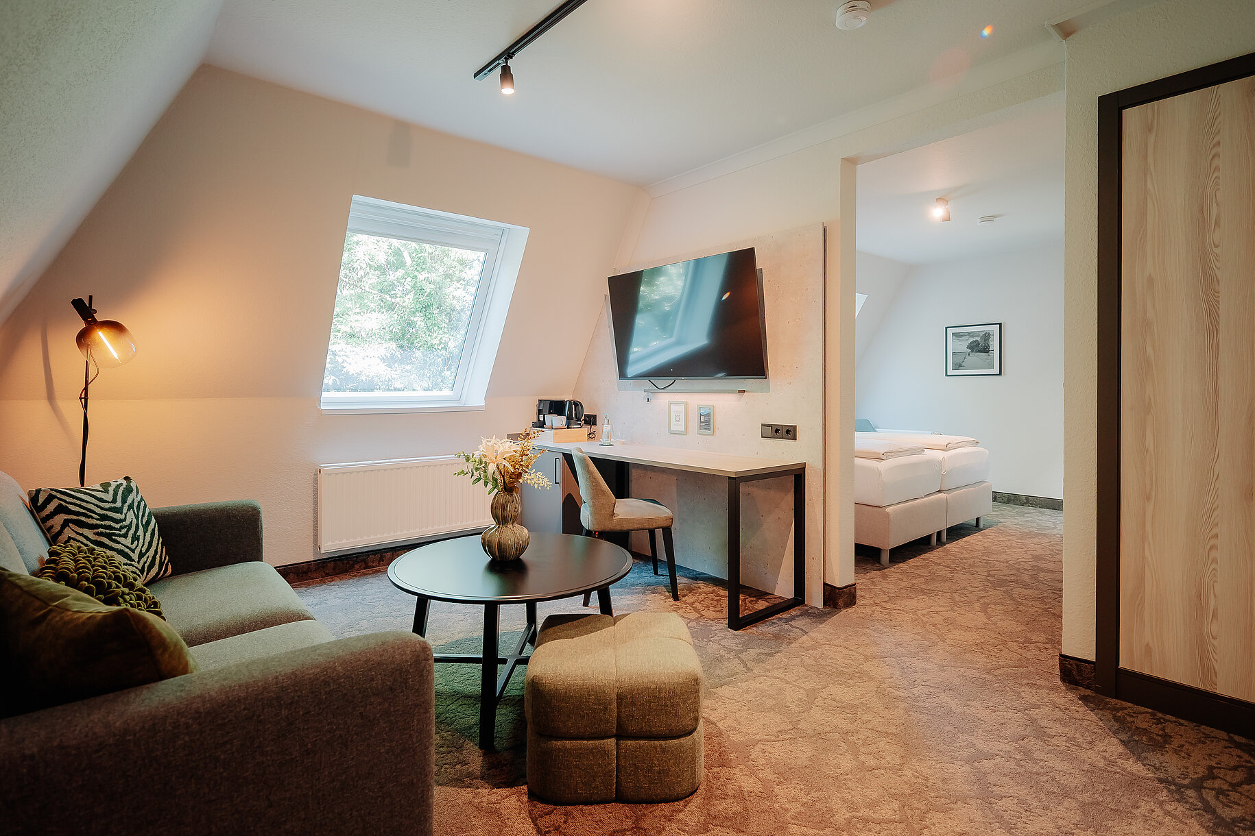 Komfort Zimmer im Parkhotel Papenburg Modernes Komfort Zimmer im Parkhotel Papenburg mit Doppelbett, Sitzbereich und offenem Badezimmer.